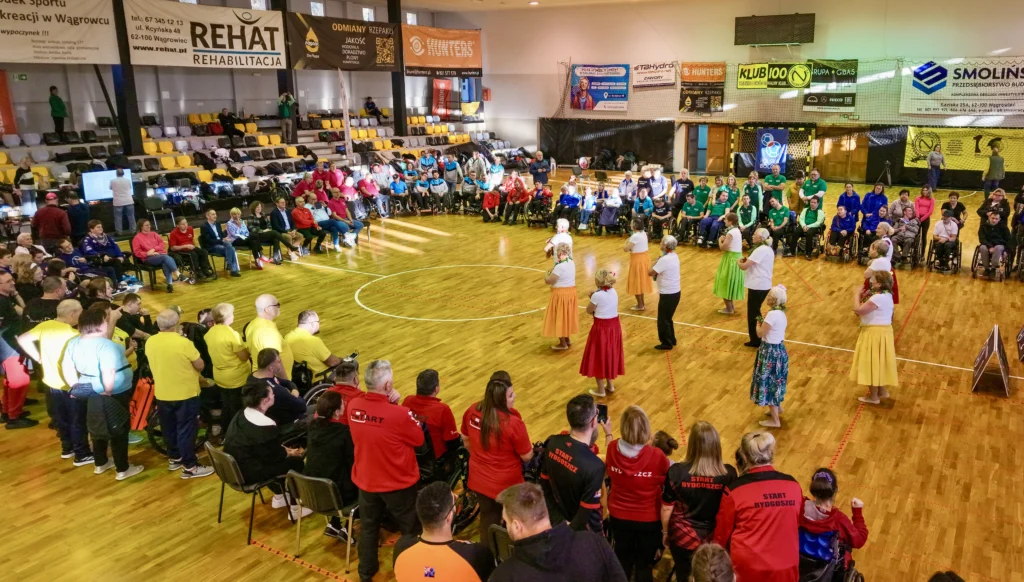 Zespół Nani Ke Ola prezentuje układ taneczny na środku hali, otoczony przez zawodników i widzów Mistrzostw Polski Boccia 2025.