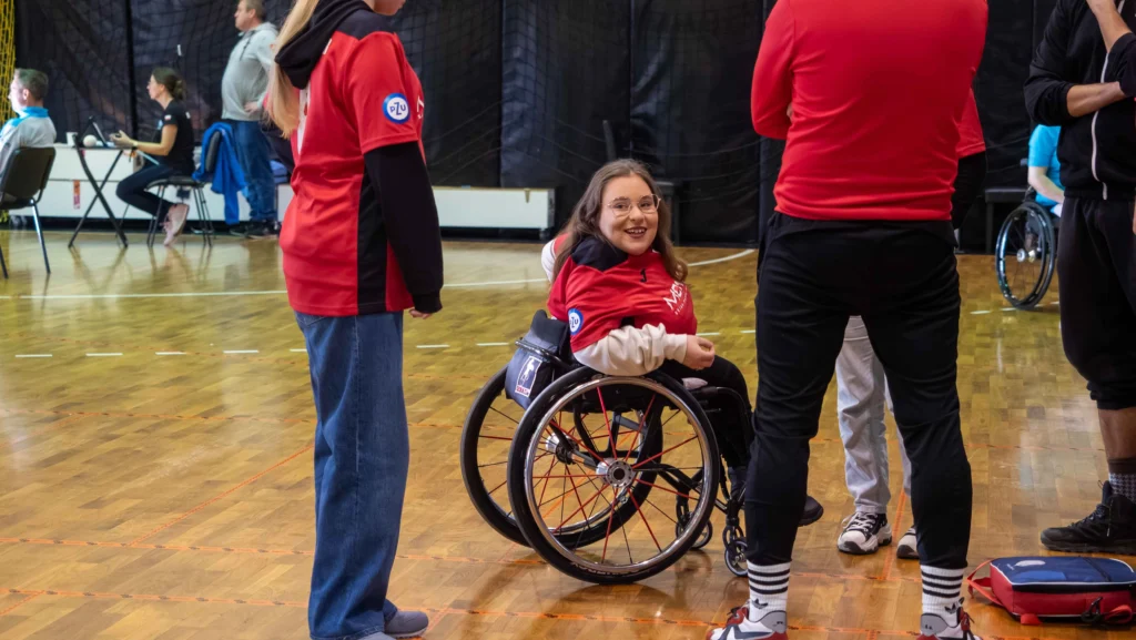 Zawodniczka bocci w czerwonej koszulce podczas rozmowy z drużyną na MP Bocci 2025.