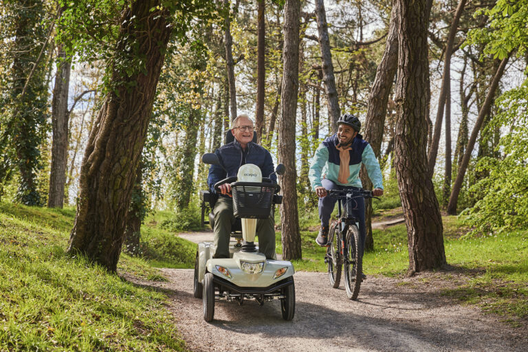 Seniorzy na skuterze Vermeiren Carpo 2 SE na leśnej ścieżce