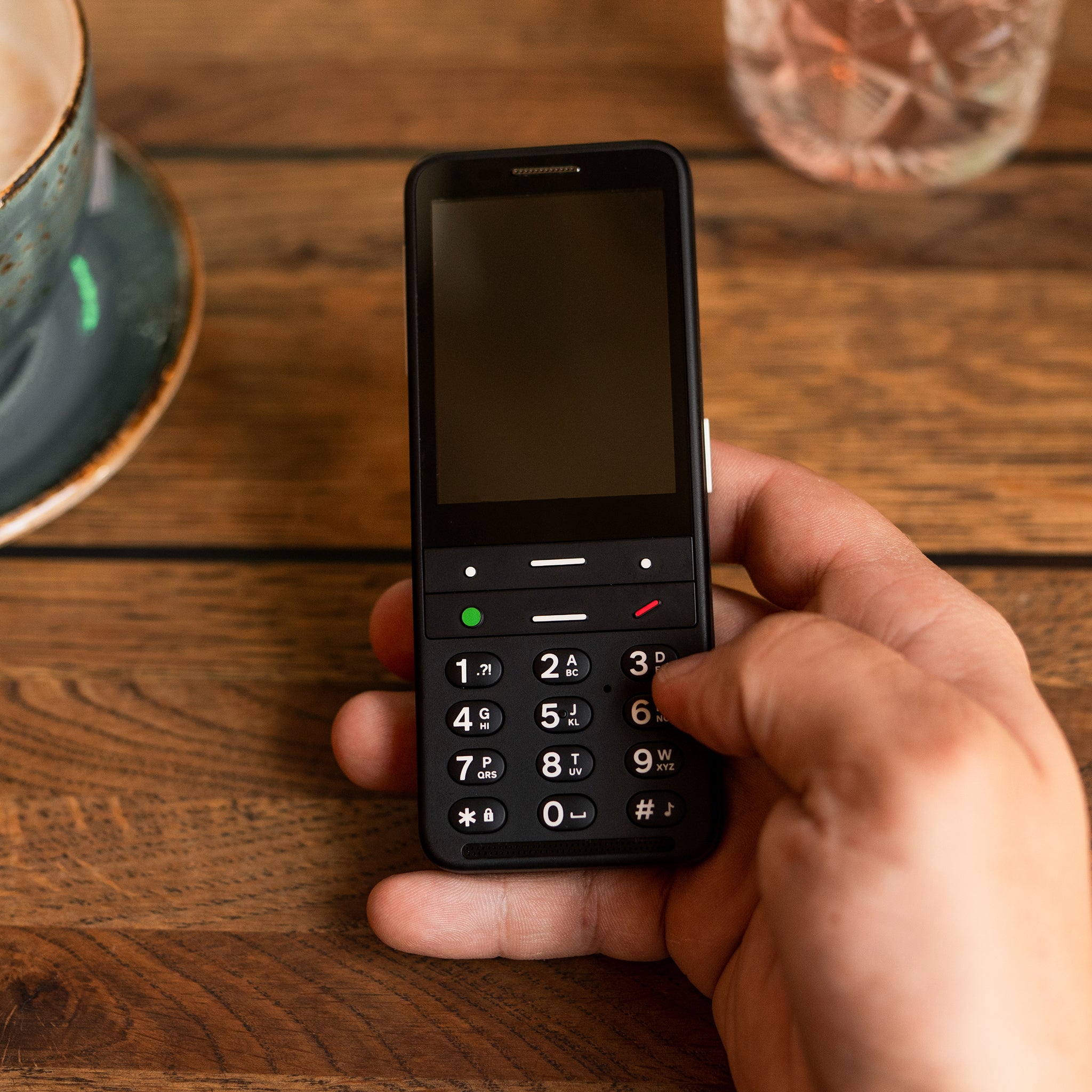 BlindShell Classic 2 w dłoni w kawiarni – telefon na co dzień dla osoby niewidomej